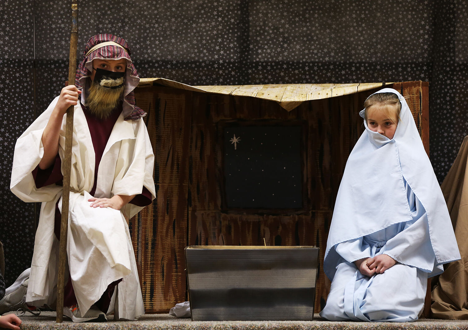 Luken Smith and Ellie Walter sit by the manger